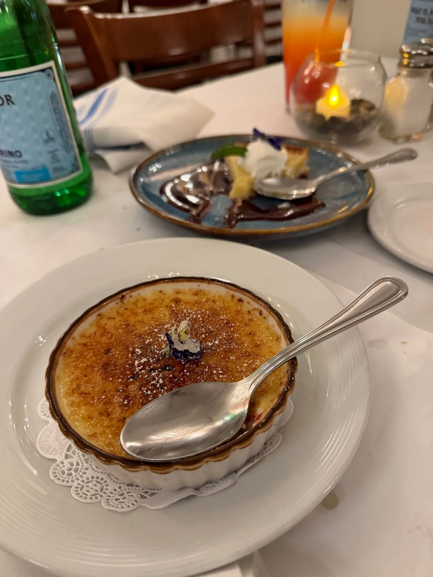 Vanilla bean crème brûlée dusted with sugar and topped with an edible flower